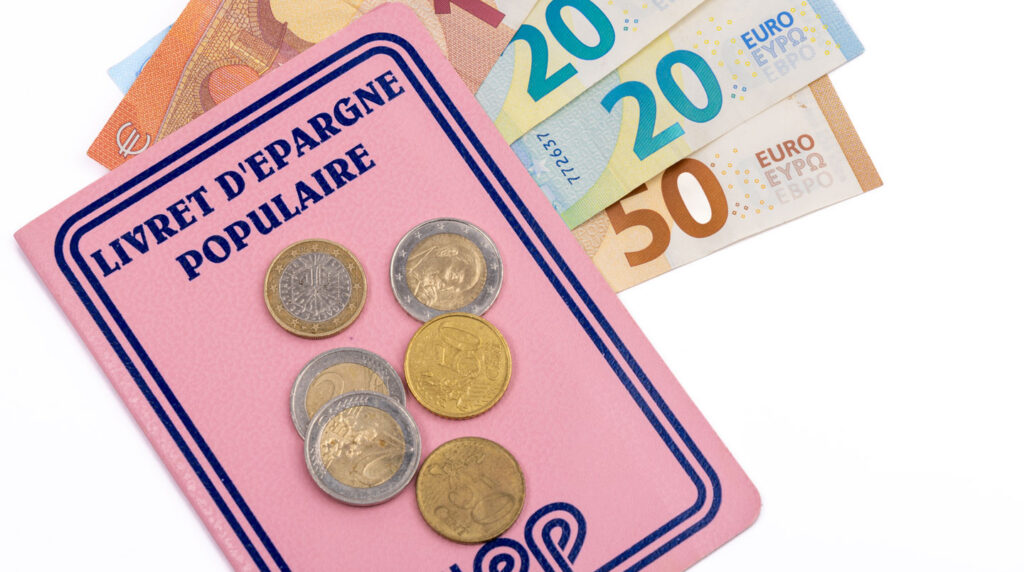 Gros plan sur une calculatrice moderne et un smartphone posés sur une surface blanche épurée, avec une main en arrière-plan effectuant un calcul Gros plan sur une calculatrice moderne et un smartphone posés sur une surface blanche épurée, avec une main en arrière-plan effectuant un calcul